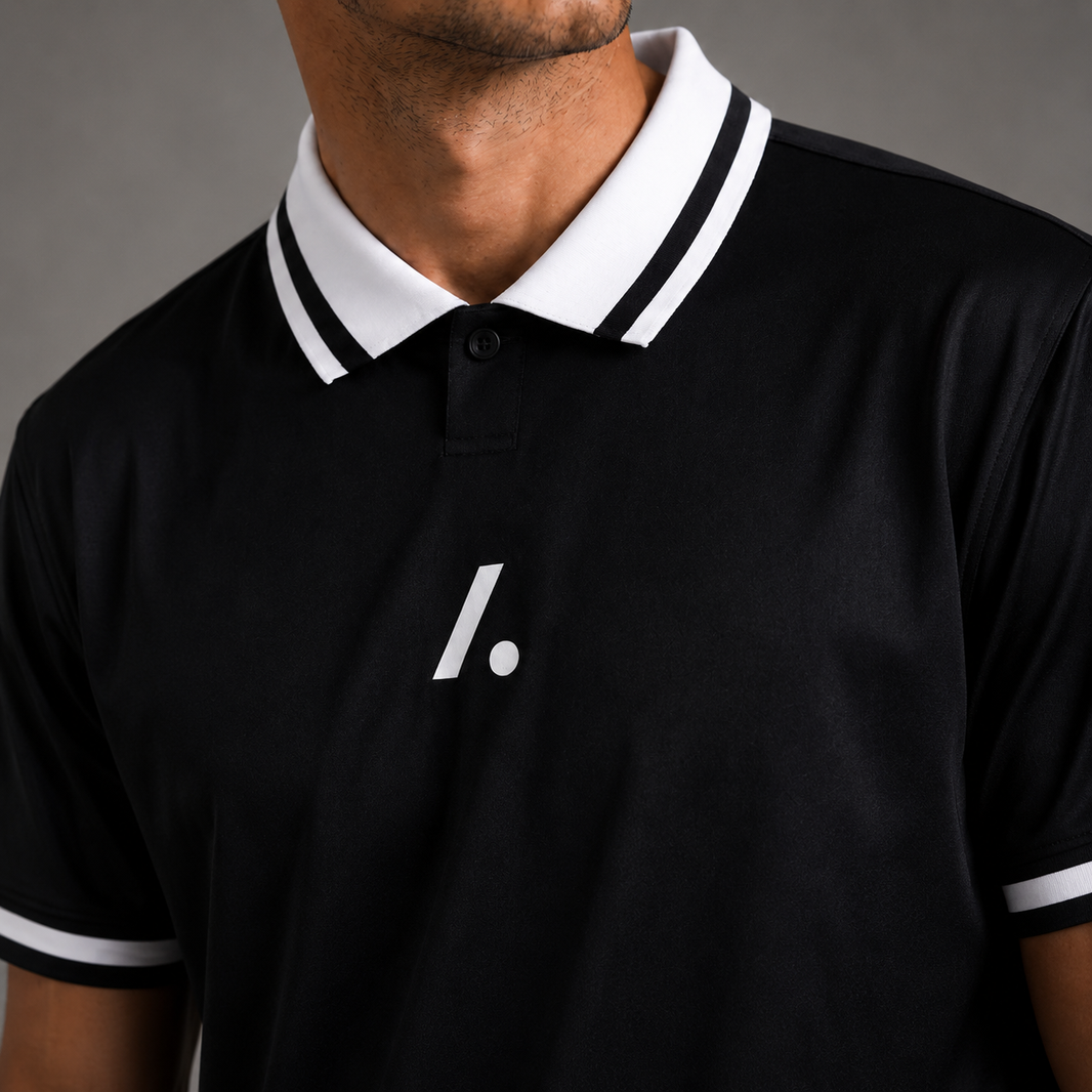 Black polo shirt with white collar and logo on a gray background