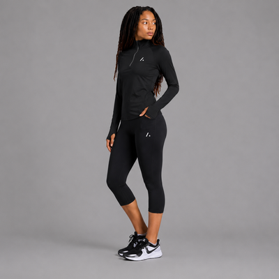 Person wearing a black athletic outfit with a gray background