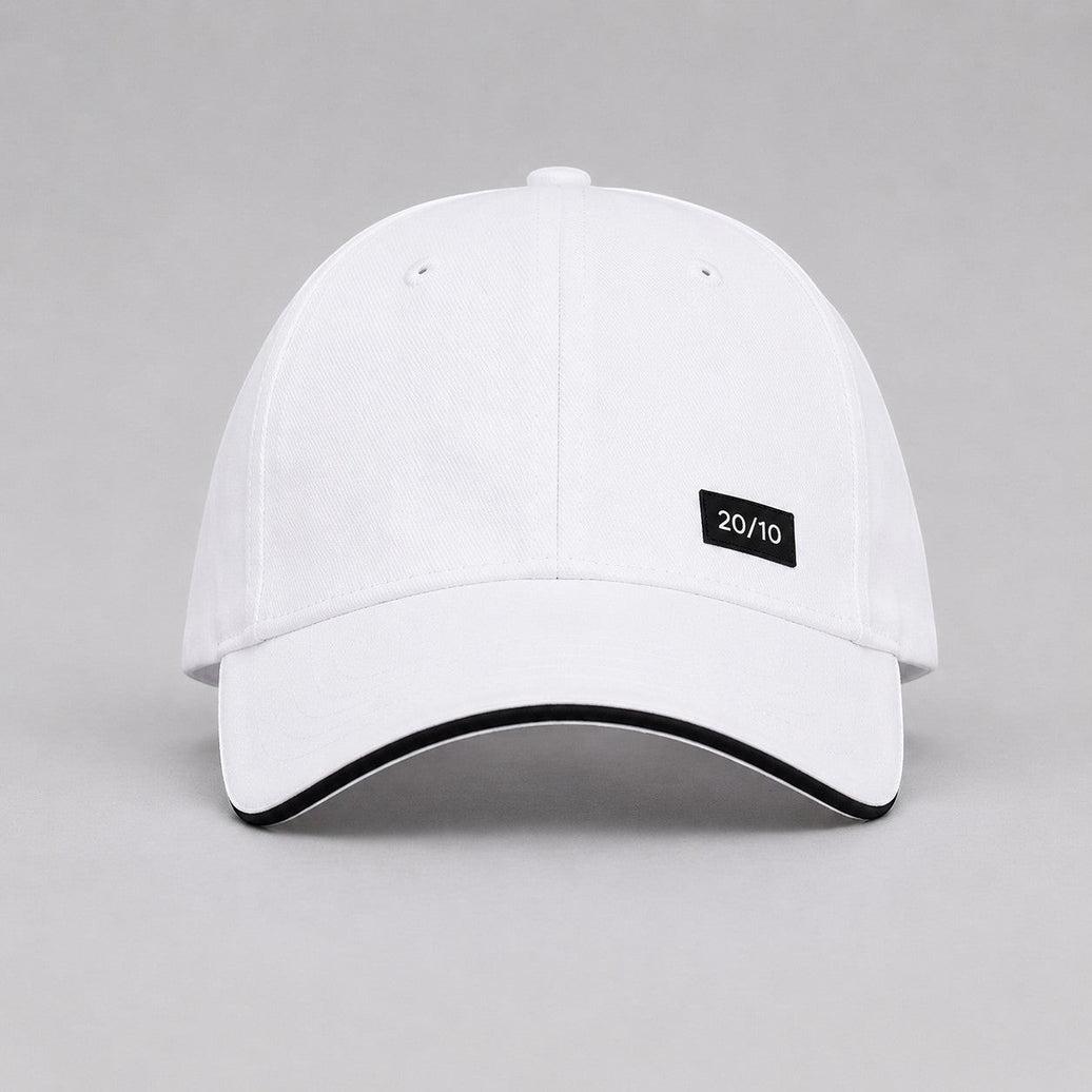 TwentyTenCollective white baseball cap with black trim and a black "20/10" logo patch.