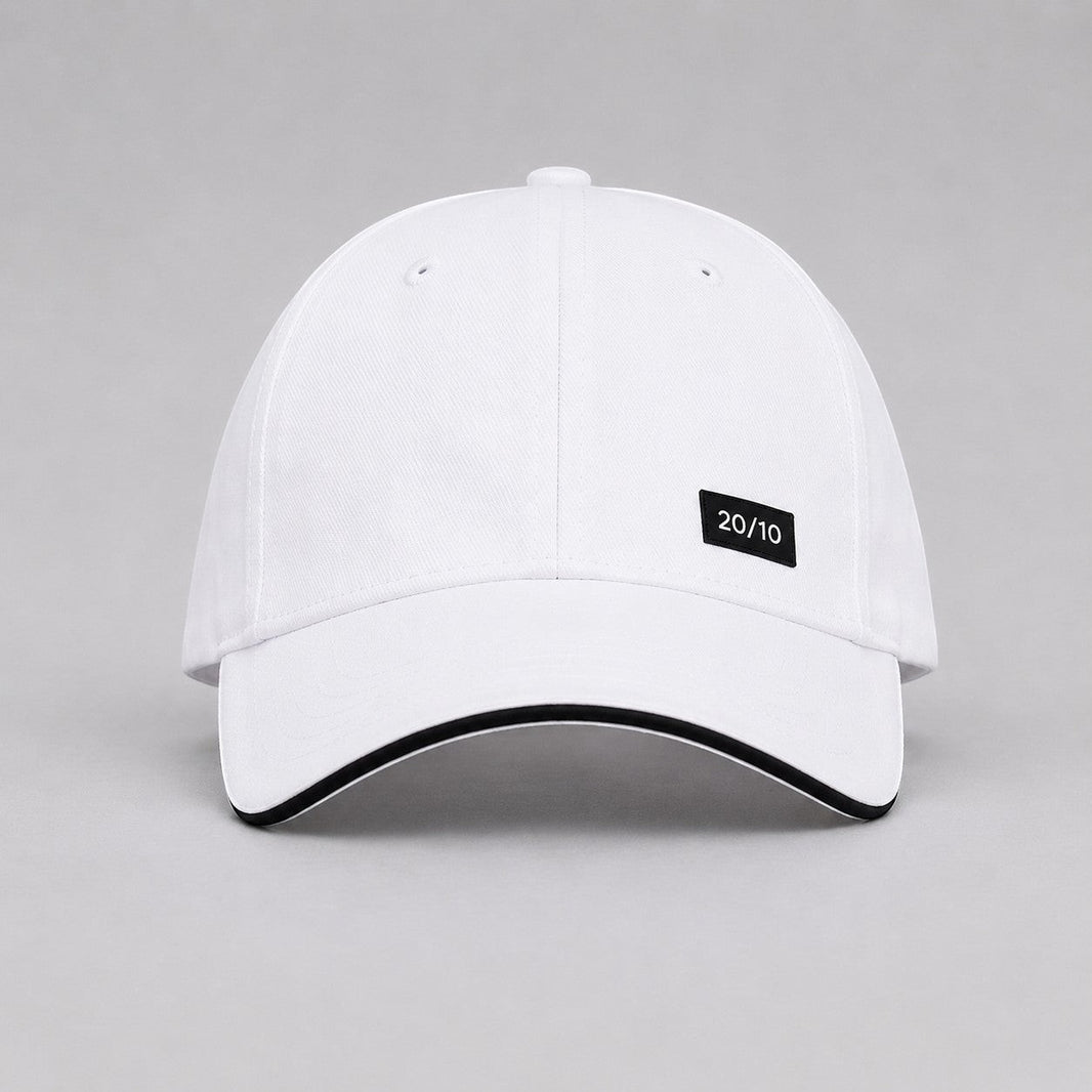 TwentyTenCollective white baseball cap with black trim and a black "20/10" logo patch.