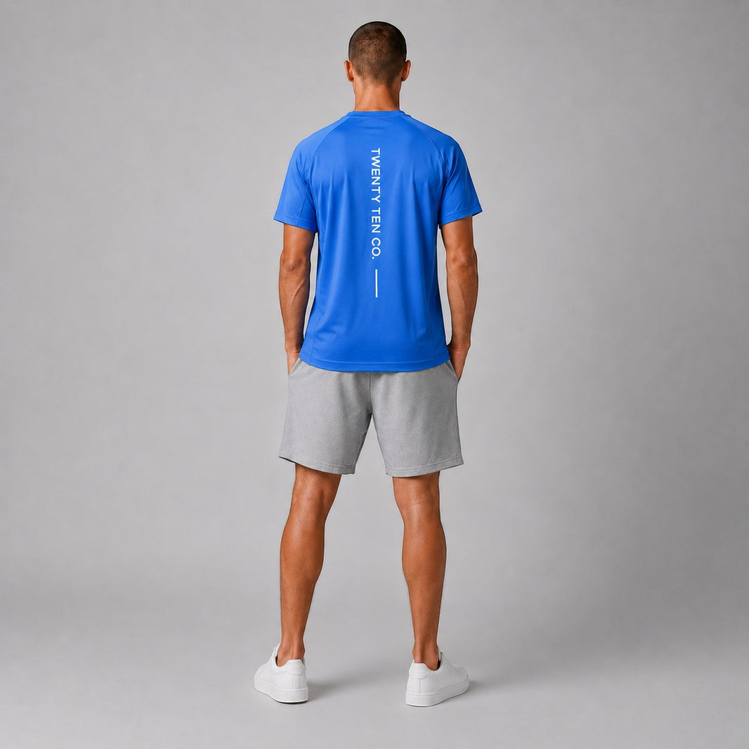 TwentyTenCo. blue athletic t-shirt with vertical white logo graphic on back, worn by a man.