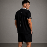 Man wearing a black polo shirt with 'TWENTY TEN CO.' branding on the back against a gray background