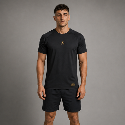 Man wearing a black t-shirt and shorts with a logo on a gray background