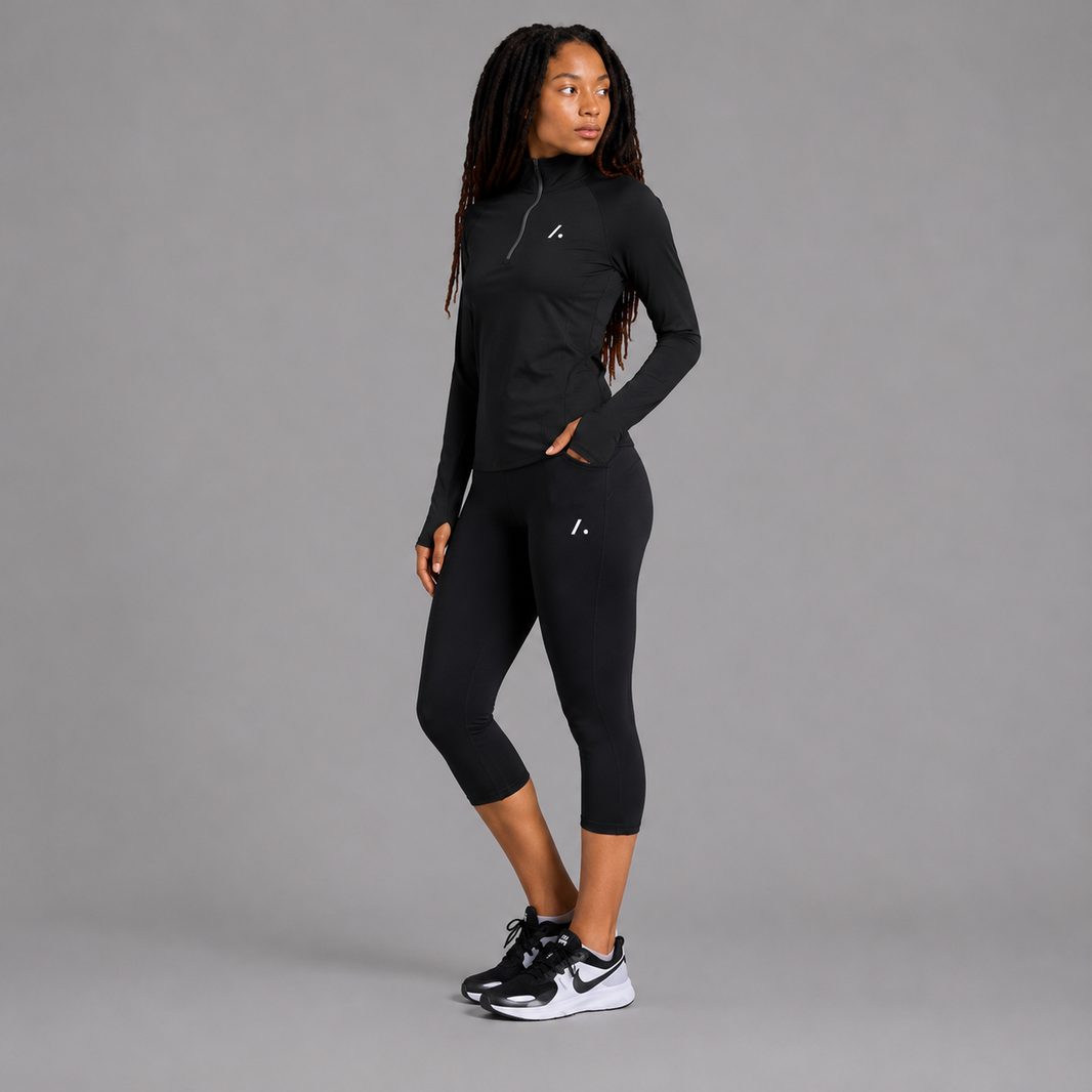 Person wearing a black athletic outfit with a gray background