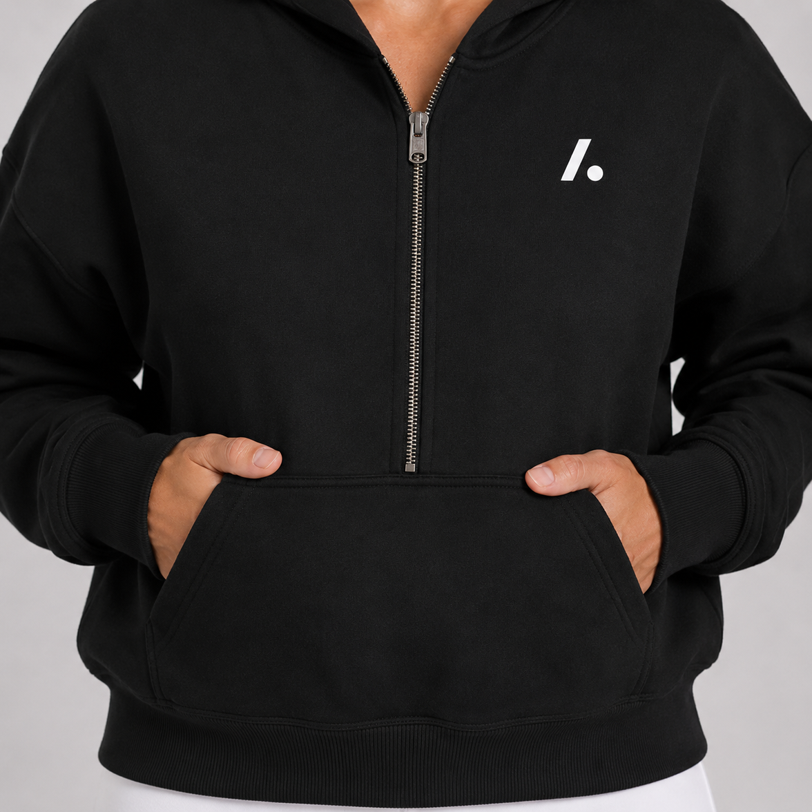 Black hoodie with a zipper and logo on a gray background
