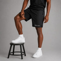 Twenty Ten Co. black athletic performance shorts with zippered pockets and elastic waistband, worn by a man.