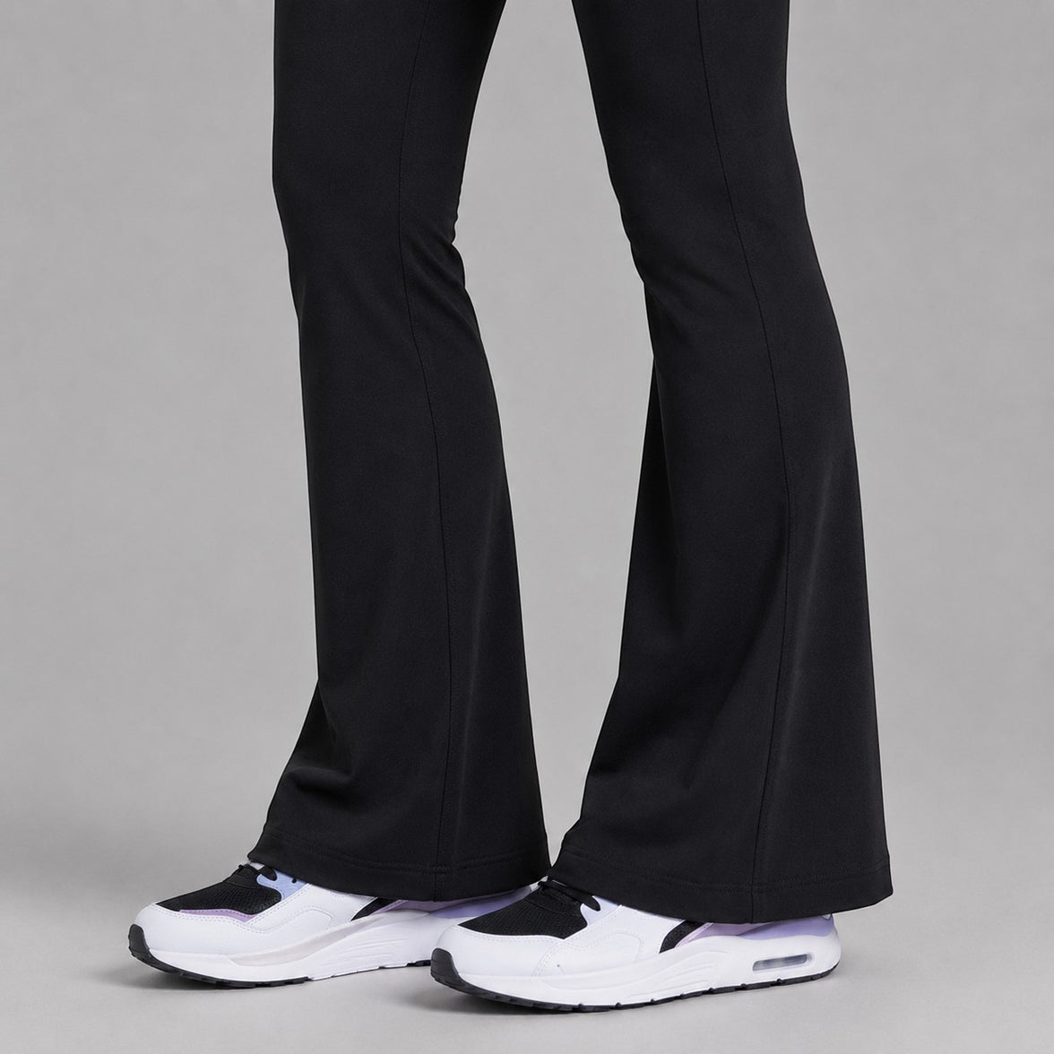 TwentyTenCollective black recycled polyester flared leggings with hidden pocket and white sneakers.