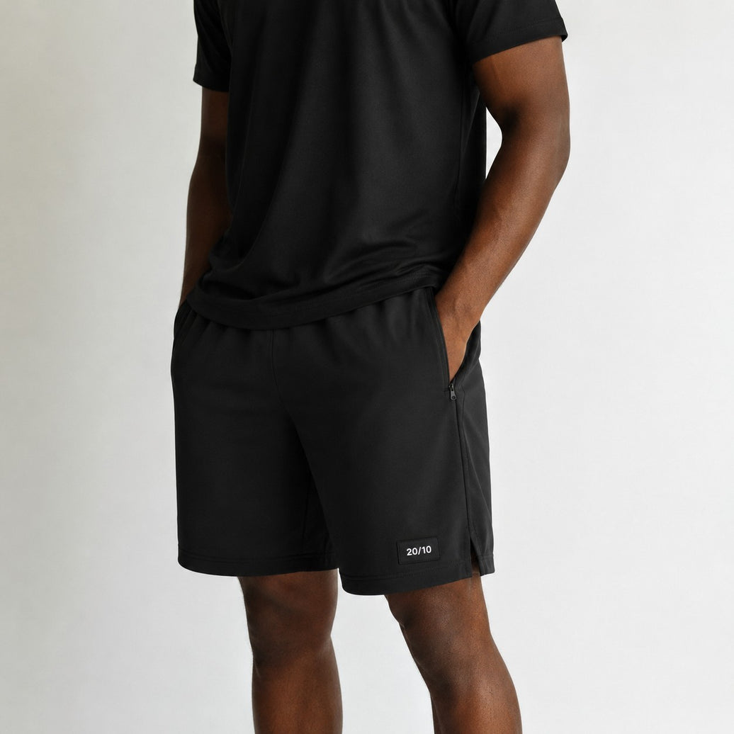 TwentyTenCollective black performance athletic shorts with zippered pockets and side vents. Lightweight, breathable fabric.