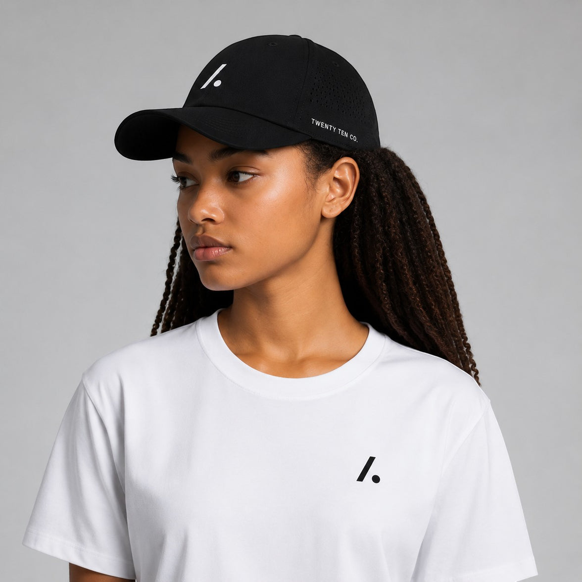 TwentyTenCollective black performance baseball cap with white logo and perforated sides, curved brim.