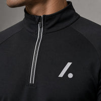 TwentyTenCollective black performance quarter zip long sleeve athletic top with reflective detailing and logo.