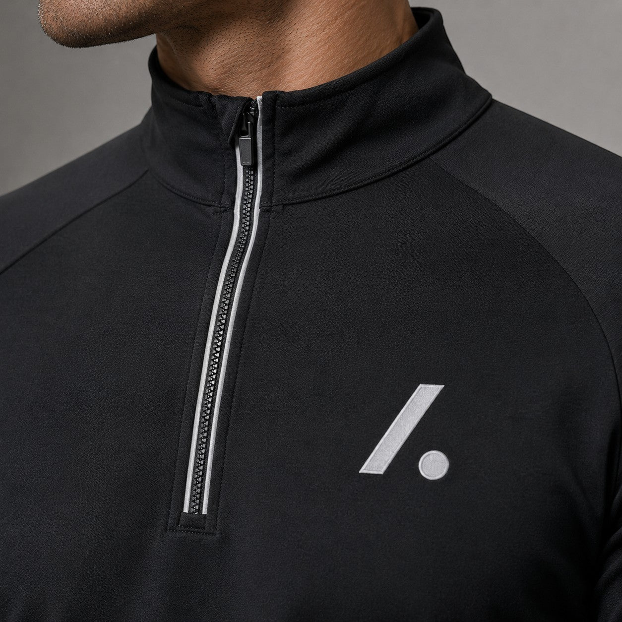 TwentyTenCollective black performance quarter zip long sleeve athletic top with reflective detailing and logo.