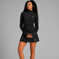 TwentyTenCollective black long sleeve performance top with quarter zip and thumbholes, paired with a matching skirt.