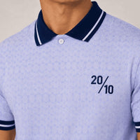 TwentyTenCollective light blue geometric pattern polo shirt with navy collar and striped cuffs. Features a two-button placket and embroidered "20/10" graphic.