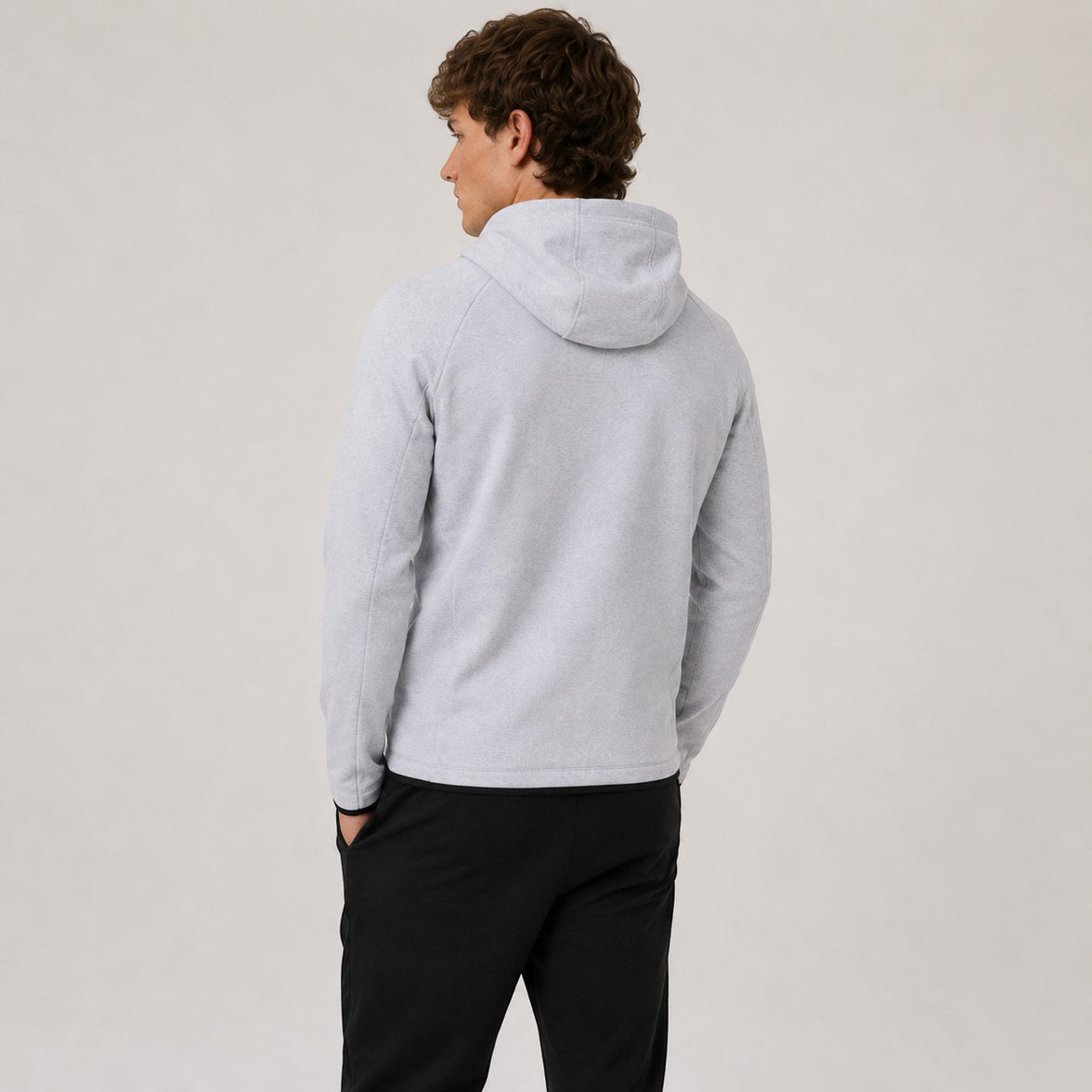 TwentyTenCollective light grey tech fleece hoodie with black trim and zippered sleeve pocket. Model from back.