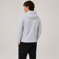 TwentyTenCollective light grey tech fleece hoodie with black trim and zippered sleeve pocket. Model from back.