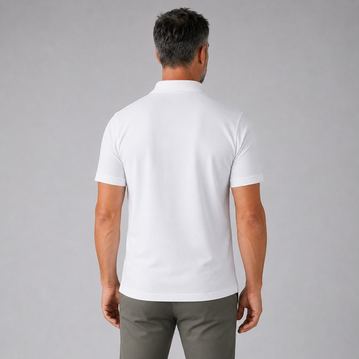 TwentyTenCollective Men's white short-sleeve performance polo shirt, back view. Model wears olive green joggers.