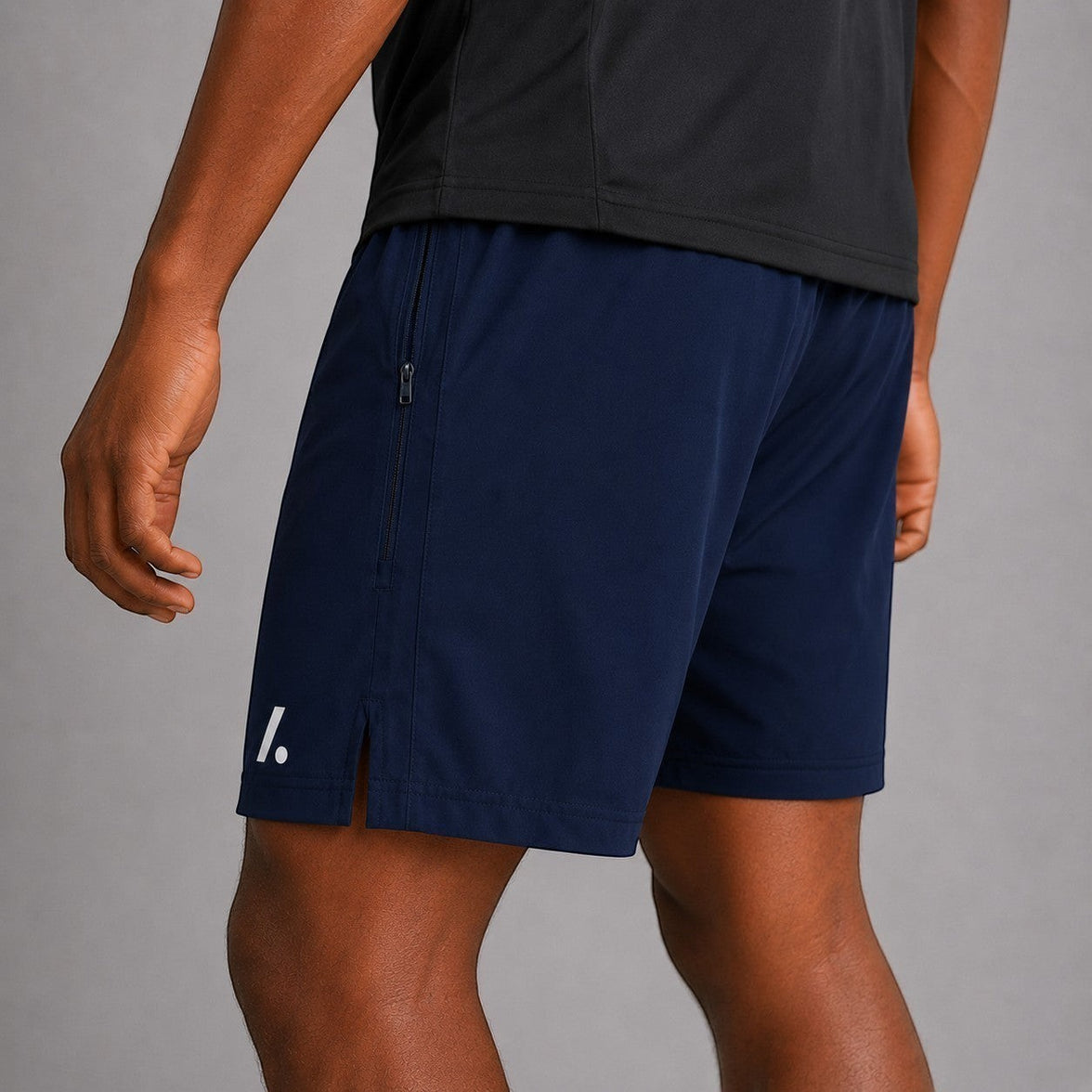 TwentyTenCollective navy blue athletic performance shorts with zippered pocket and white logo accent.