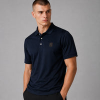 TwentyTenCollective classic navy blue short sleeve polo shirt with embroidered emblem on chest. Model is wearing a size M.