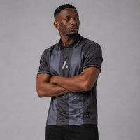 TwentyTenCollective charcoal and dark grey striped athletic polo shirt with a two-button placket and reflective logo.