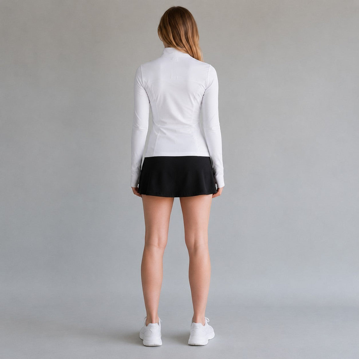TwentyTenCollective white athletic full zip jacket with mock neck and thumbholes, paired with a black skirt.