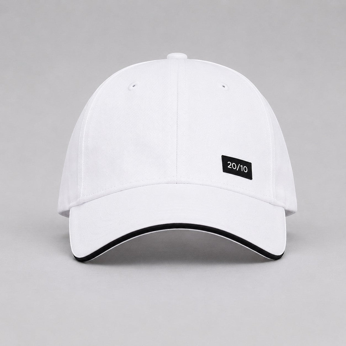TwentyTenCollective white baseball cap with black trim and a black "20/10" logo patch.