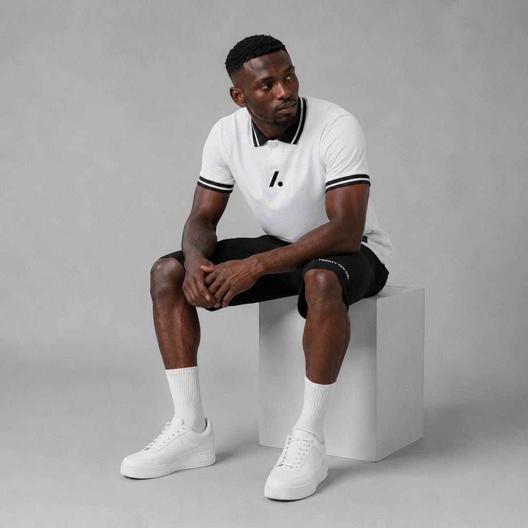 TwentyTenCollective men's white short sleeve polo shirt with black striped collar and cuffs, two-button placket, and chest logo.