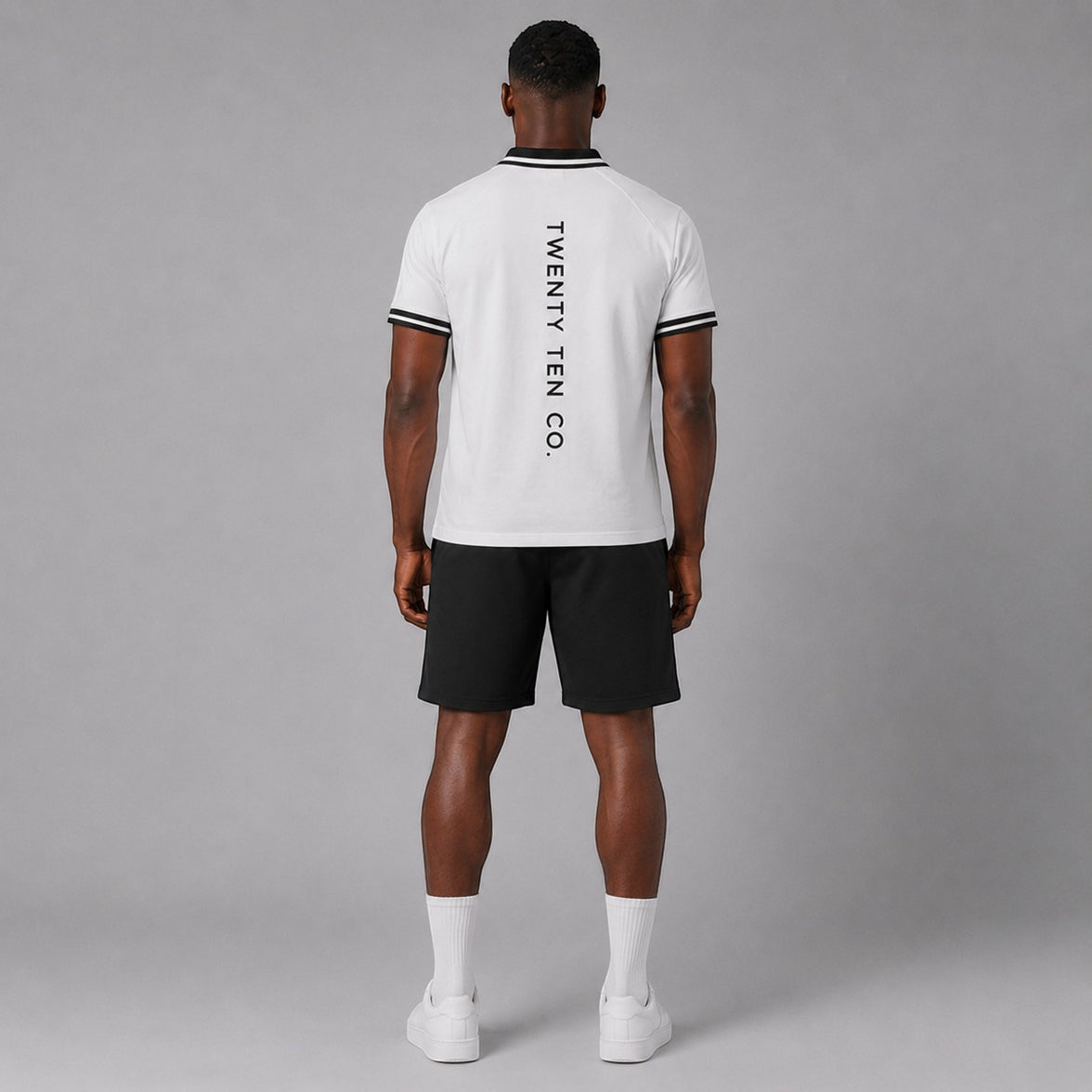 TwentyTenCollective men's white short sleeve polo shirt with black striped collar and cuffs, and vertical logo on back.