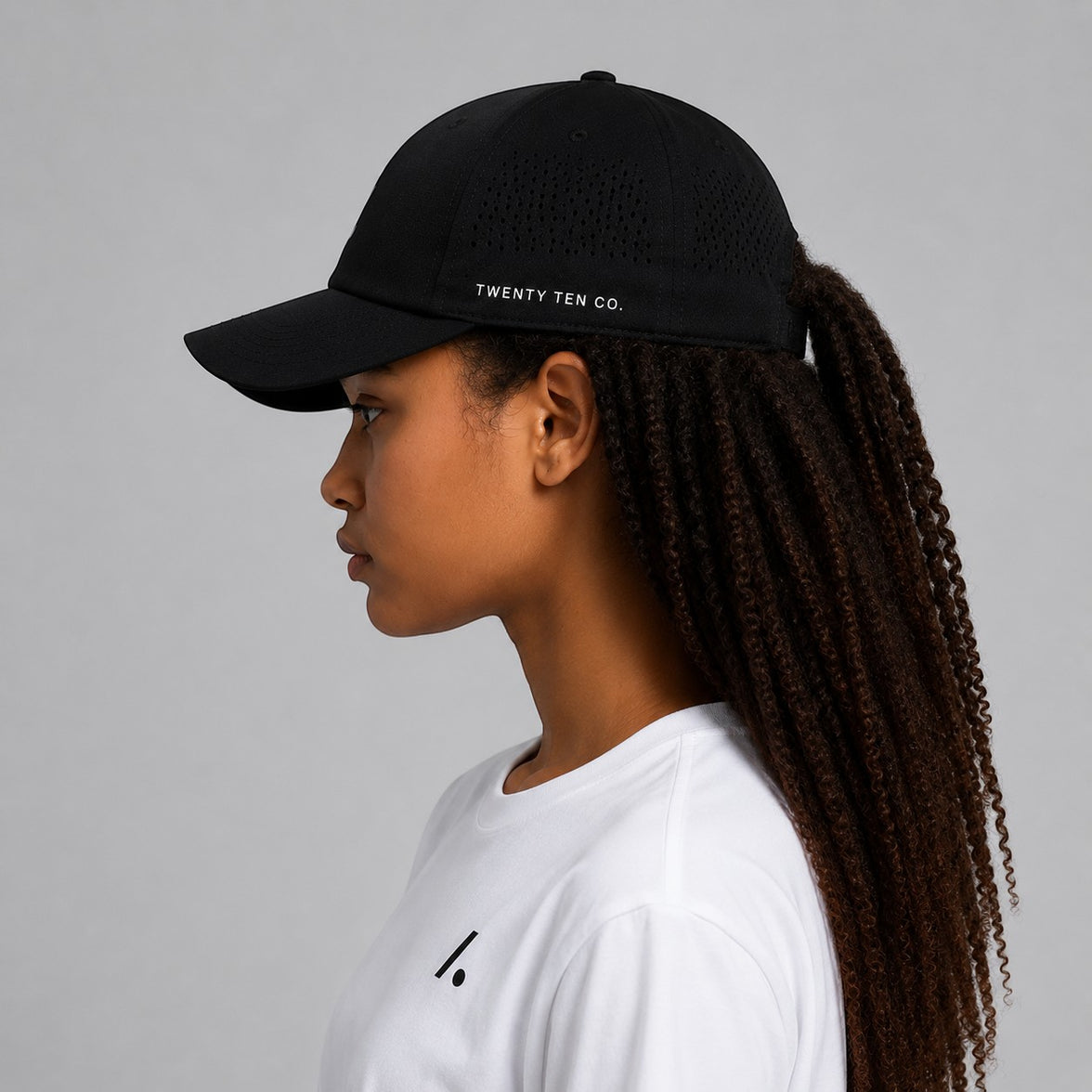 TwentyTenCo black performance baseball cap with perforated sides and white logo, curved brim for sun protection.