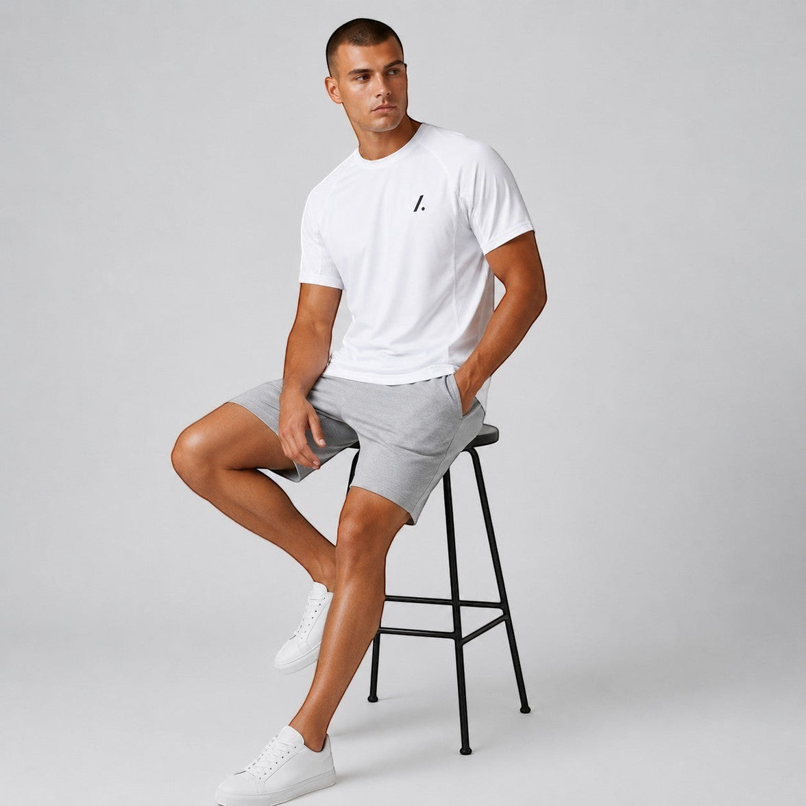 TwentyTenCollective white crew neck t-shirt with raglan sleeves and grey athletic shorts set on a man.