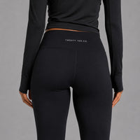 TwentyTenCollective black high-rise performance athletic leggings with moisture-wicking fabric and logo detail.