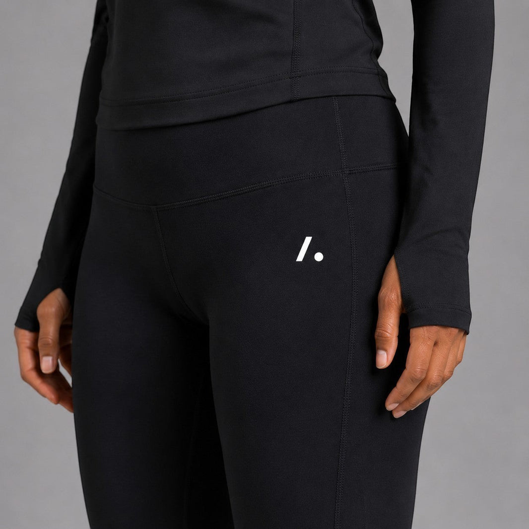 TwentyTenCollective high-rise black athletic leggings with moisture-wicking fabric and minimalist logo detail.