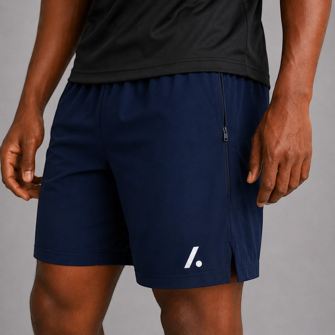 TwentyTenCollective navy blue athletic performance shorts with zipper pockets and white logo accent.