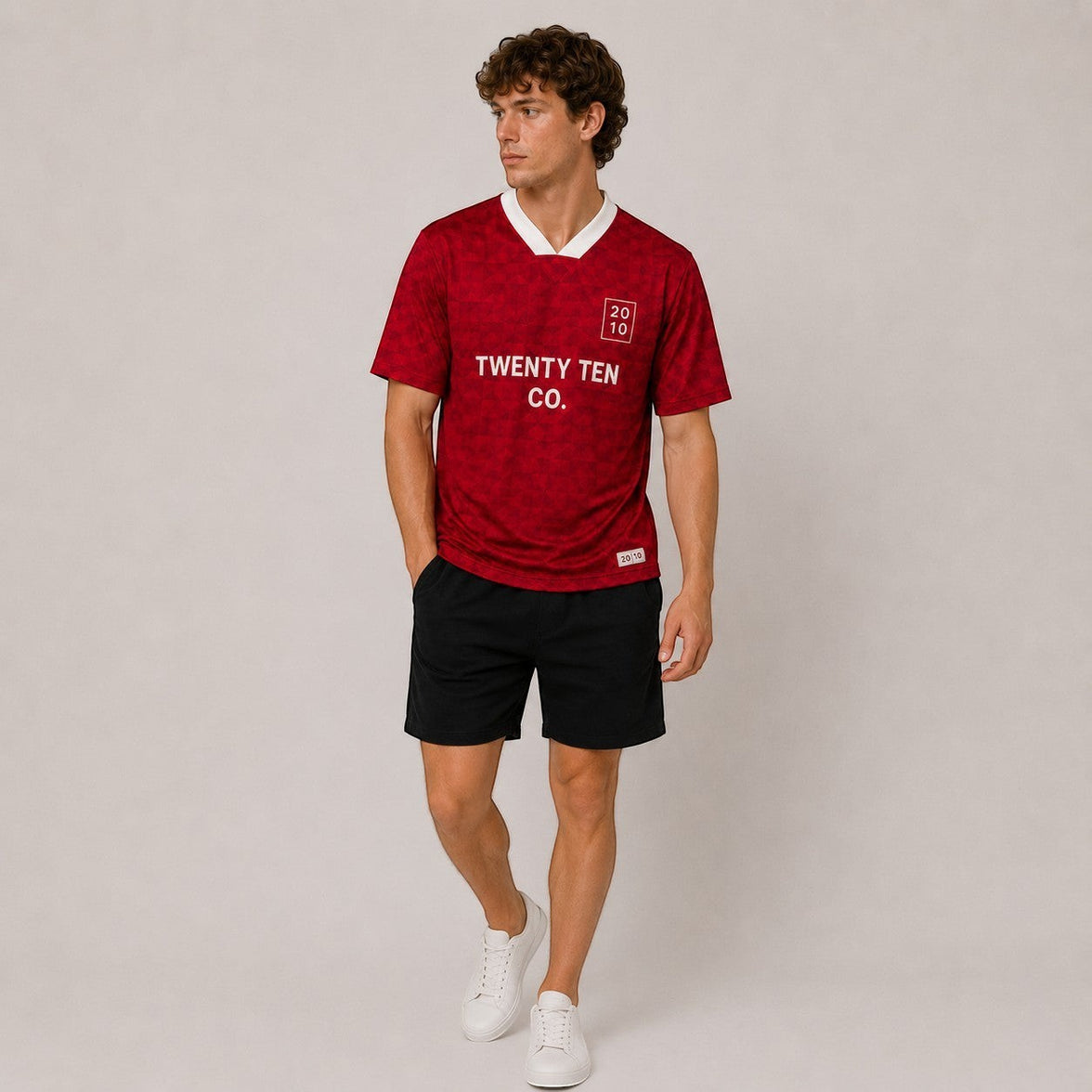 TwentyTenCo. Athletic Short Sleeve Jersey in vibrant red with a subtle geometric pattern and white trim. Features crew neck and minimalist logo.